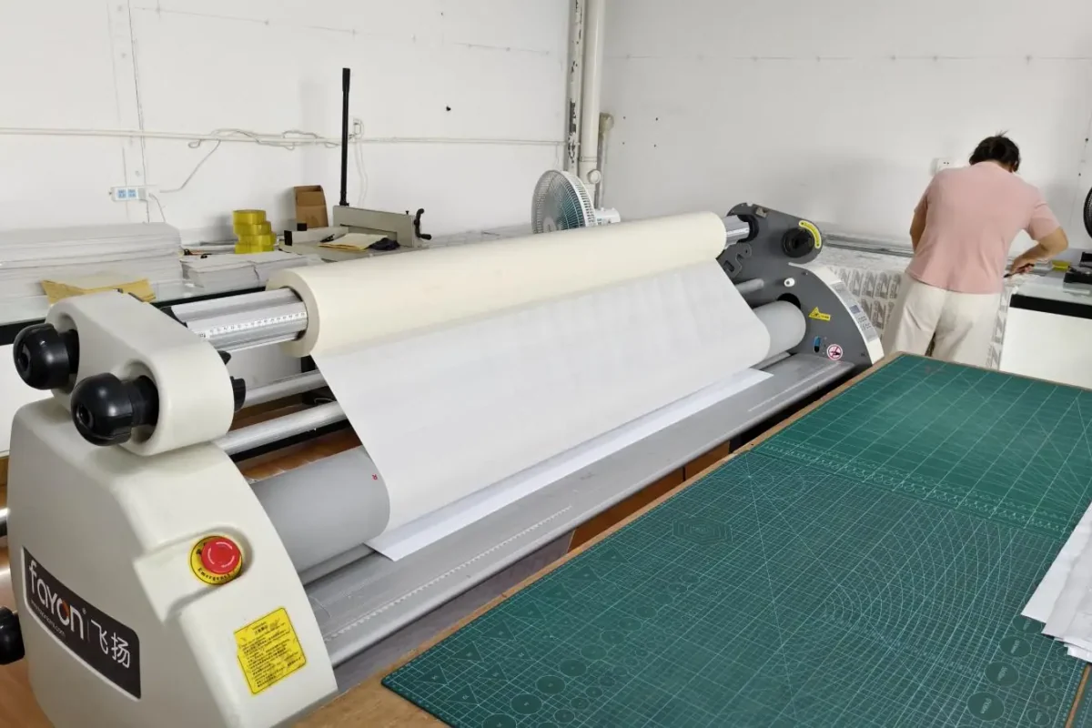 A laminating roller and cutting mat in the workshop.