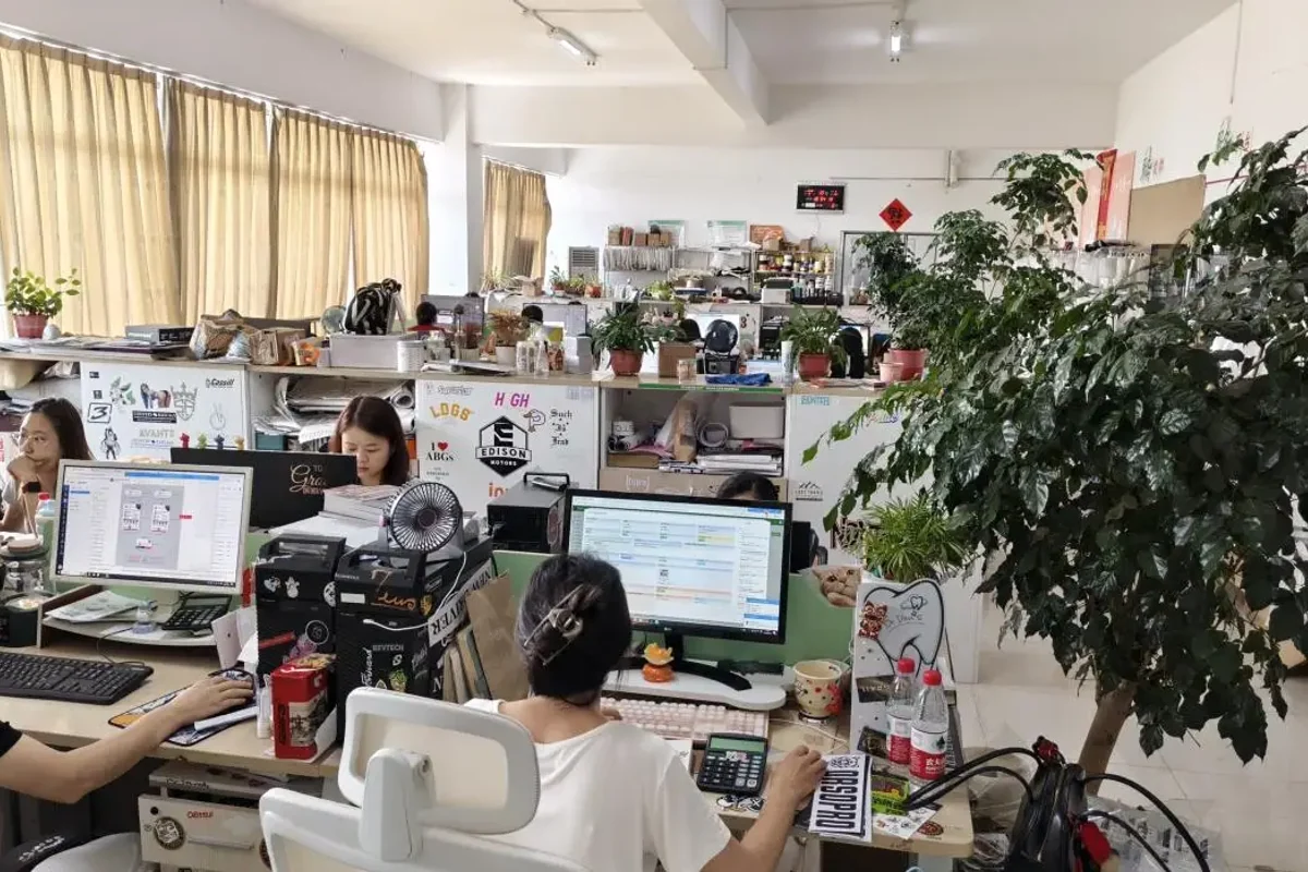 The office workspace with desks, computers and plants.