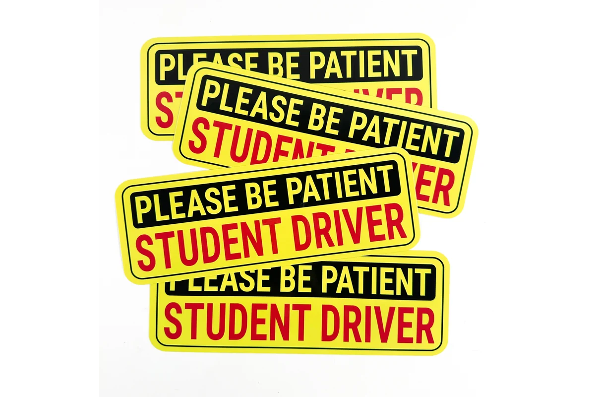 A stack of rectangular yellow student driver bumper stickers.