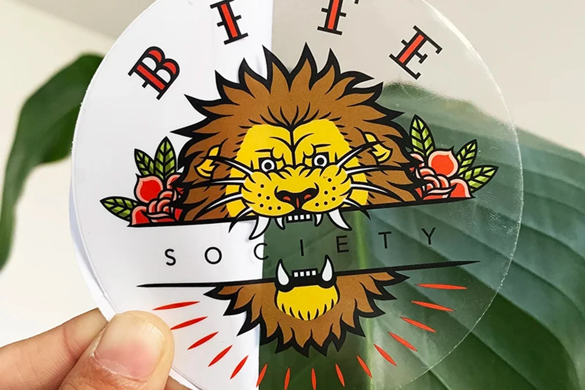 A clear illustrated label held in front of green leaves