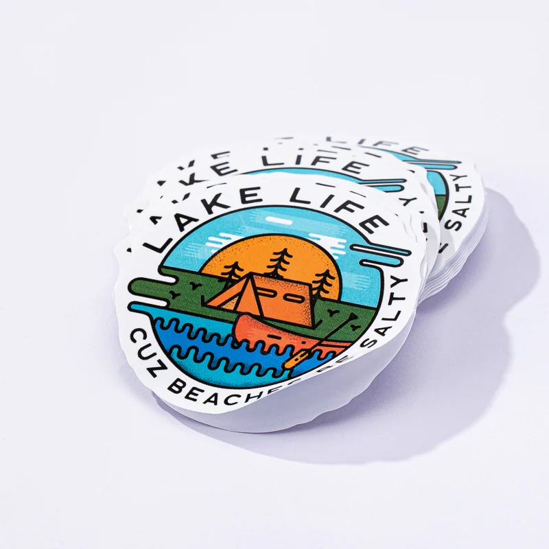 Round outdoor logo stickers stacked on a white surface
