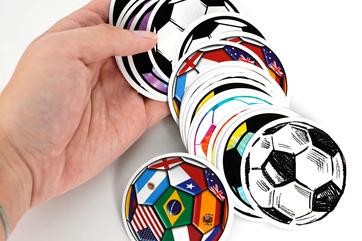 A fan of printed round sticker samples held by hand