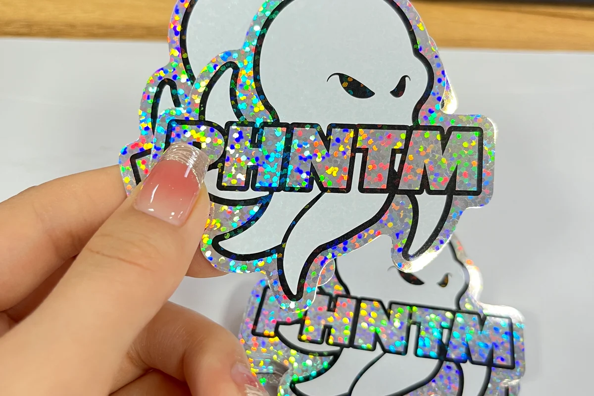 Hand holding shaped stickers with a sparkling finish