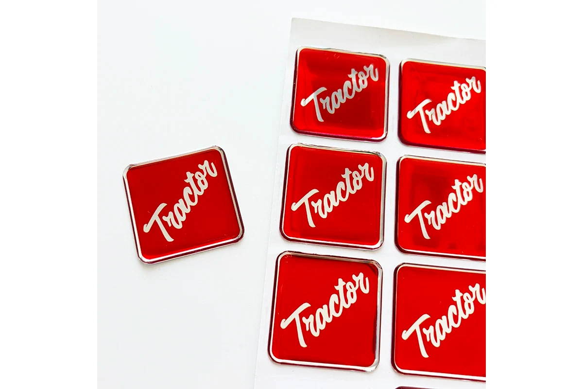 Red rectangular domed labels with white lettering on a backing sheet.