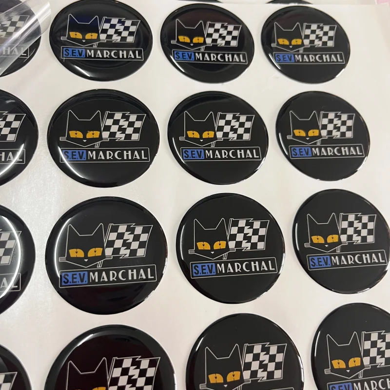 Black circular logo badges with a raised clear epoxy surface.