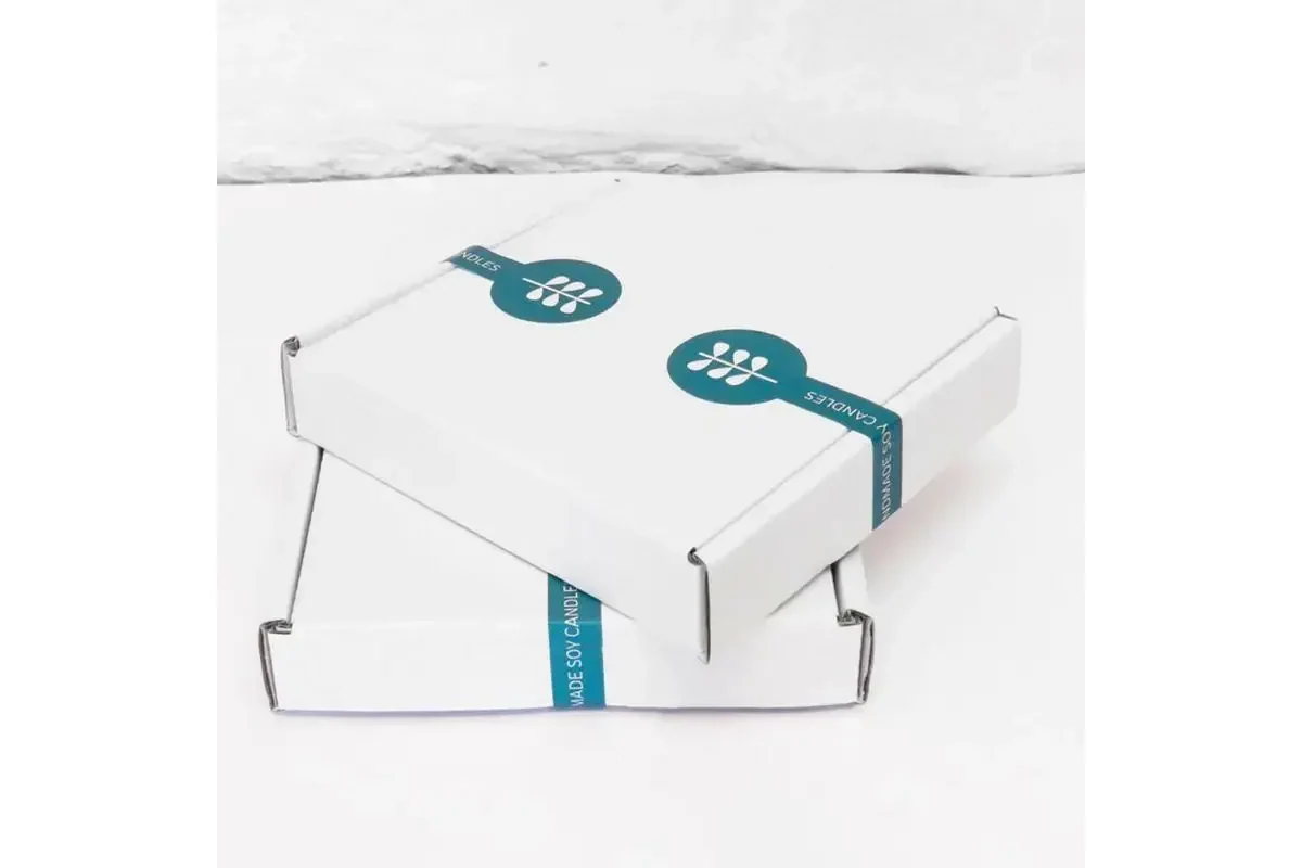 Teal sealing labels applied across the lids of two white cartons