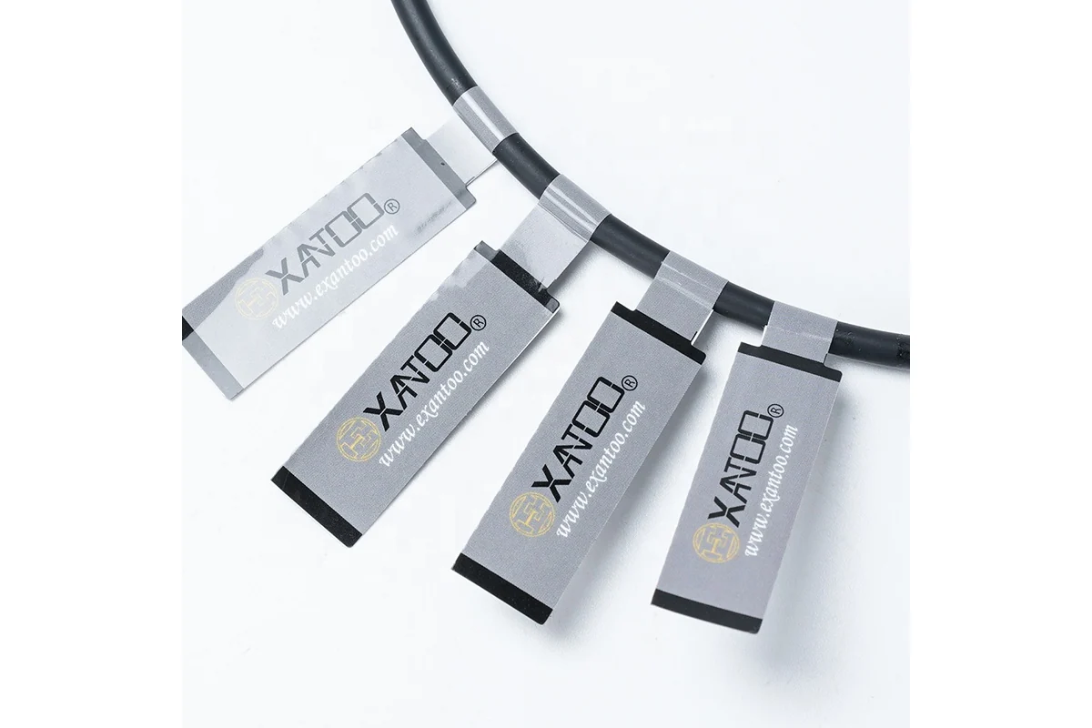 Several gray printed identification labels wrapped around a black cable.