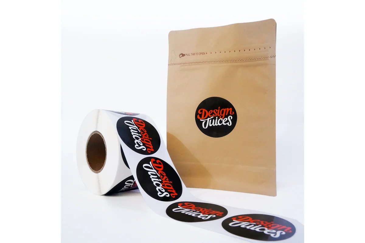 A roll of round printed labels beside a kraft packaging bag