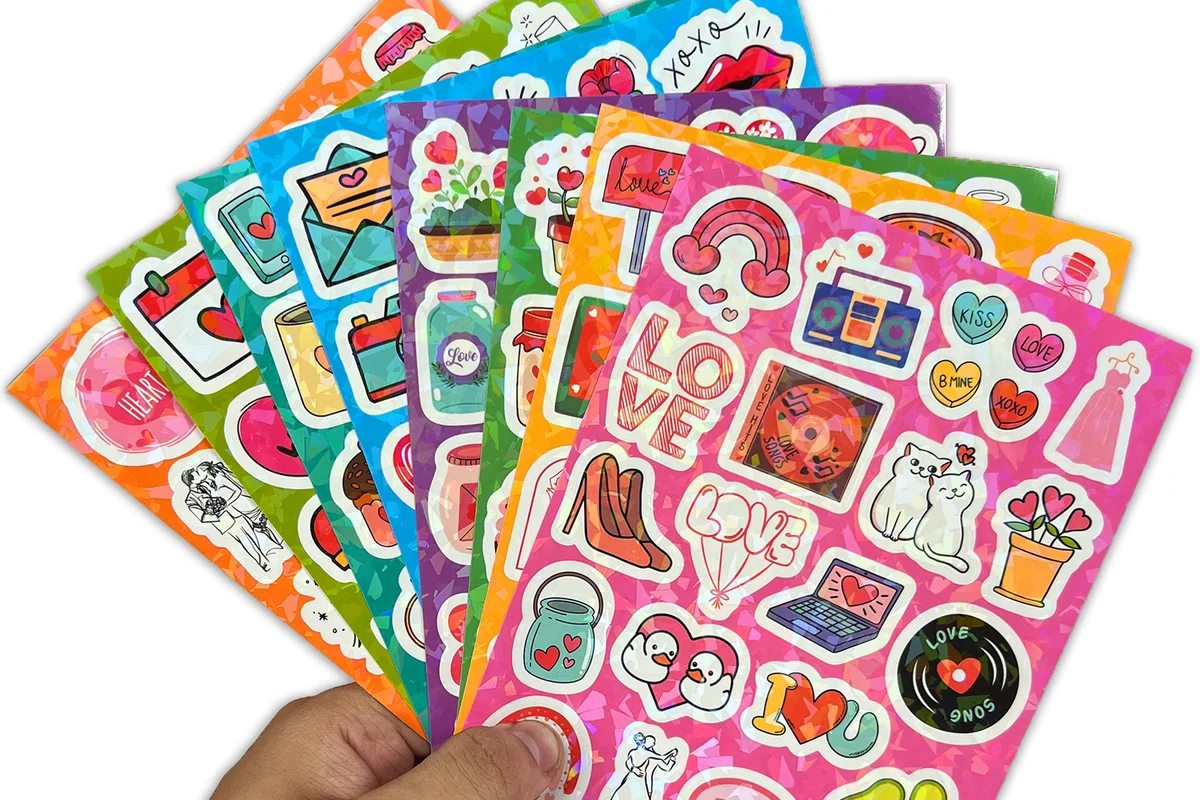 Hand holding several colorful sticker sheet sets