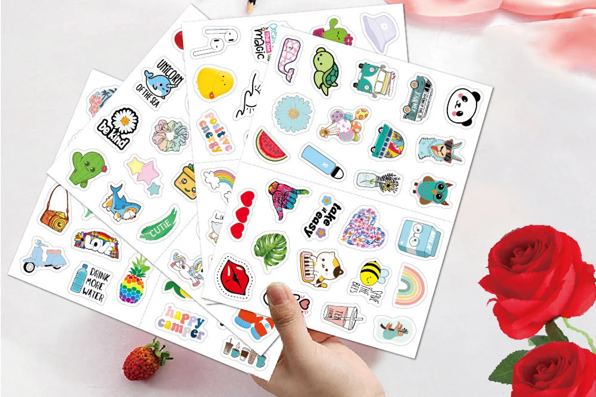 Hand holding two printed sticker sheets