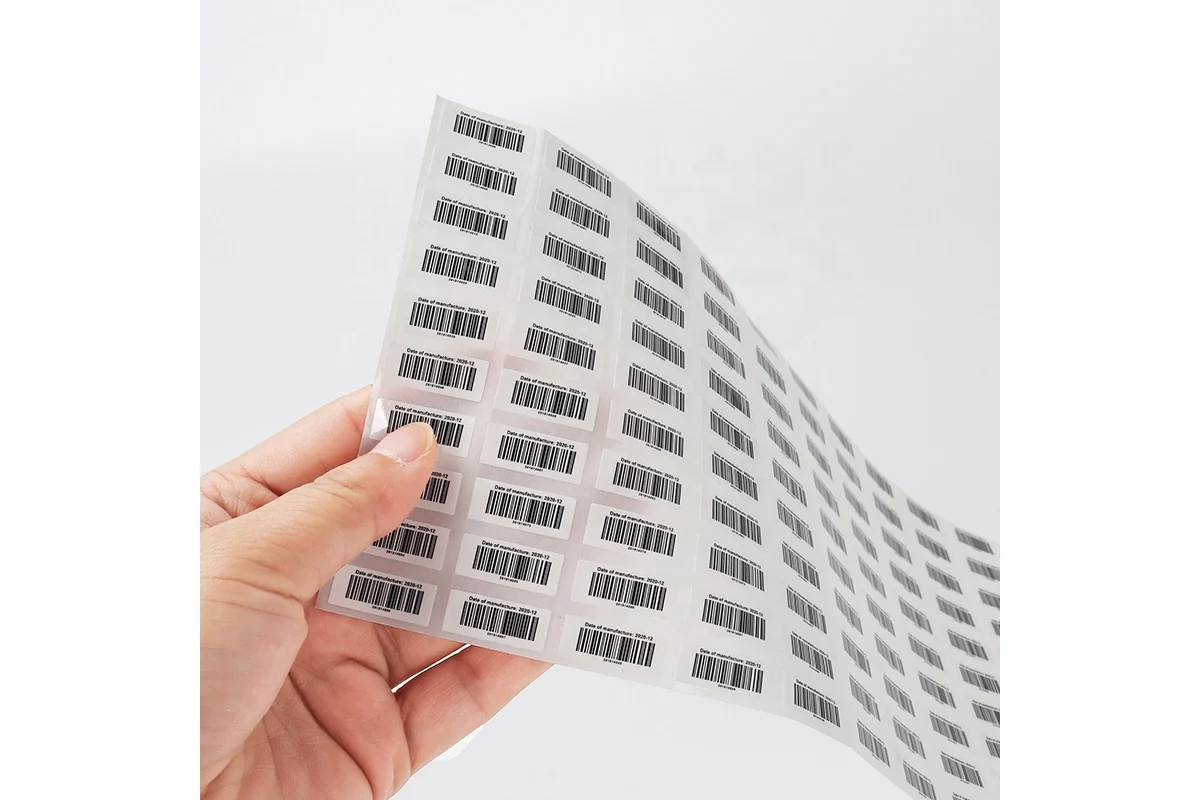 A flexible sheet of small white labels printed with black barcodes.