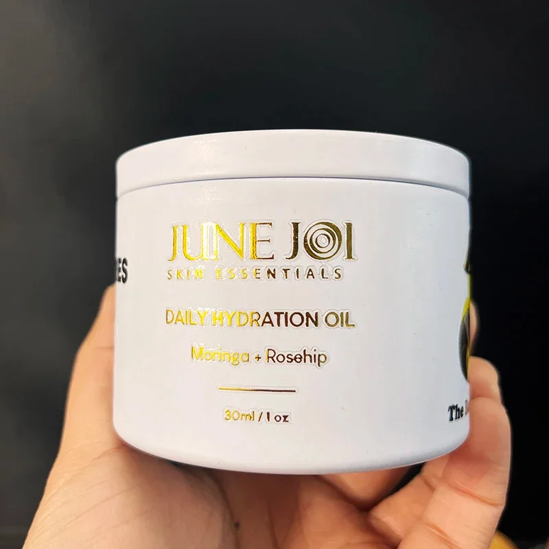 Gold lettering transferred to the face of a white cosmetic jar.