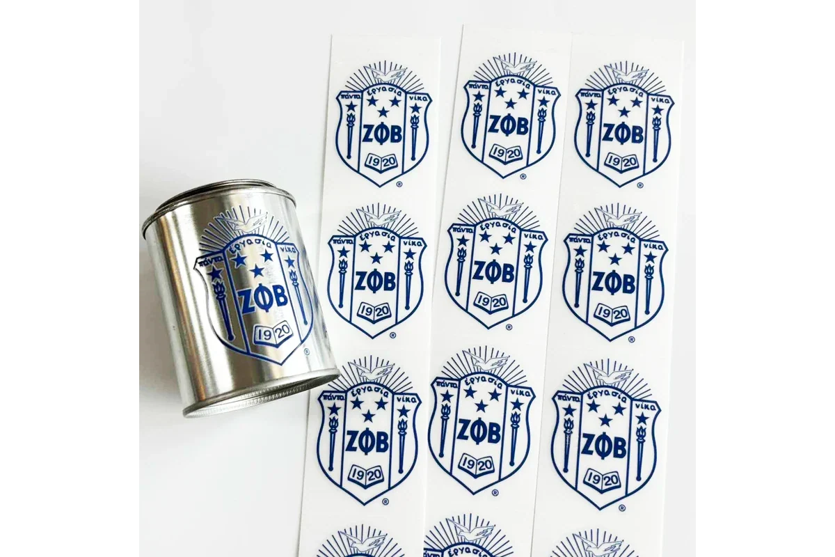 A printed logo carrier sheet beside a metal tin bearing the matching design.