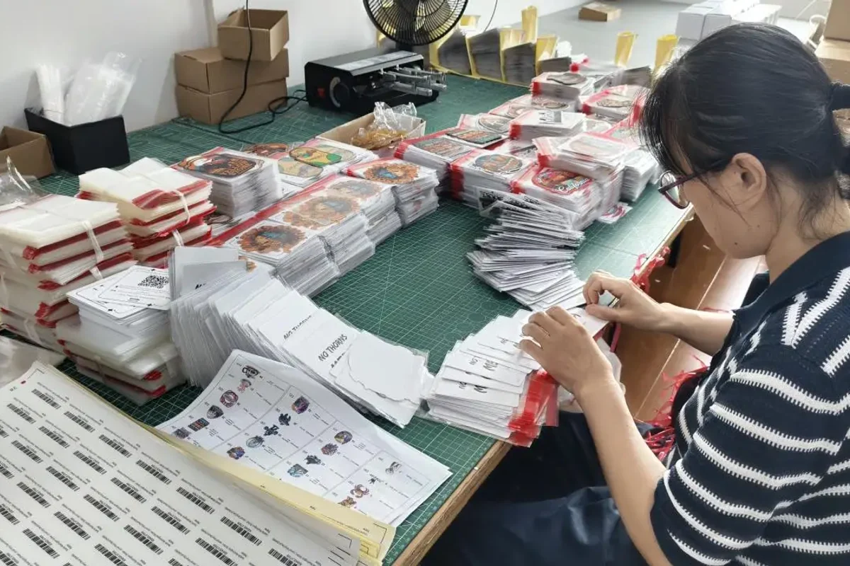 A team member checking printed sheets at a workbench.
